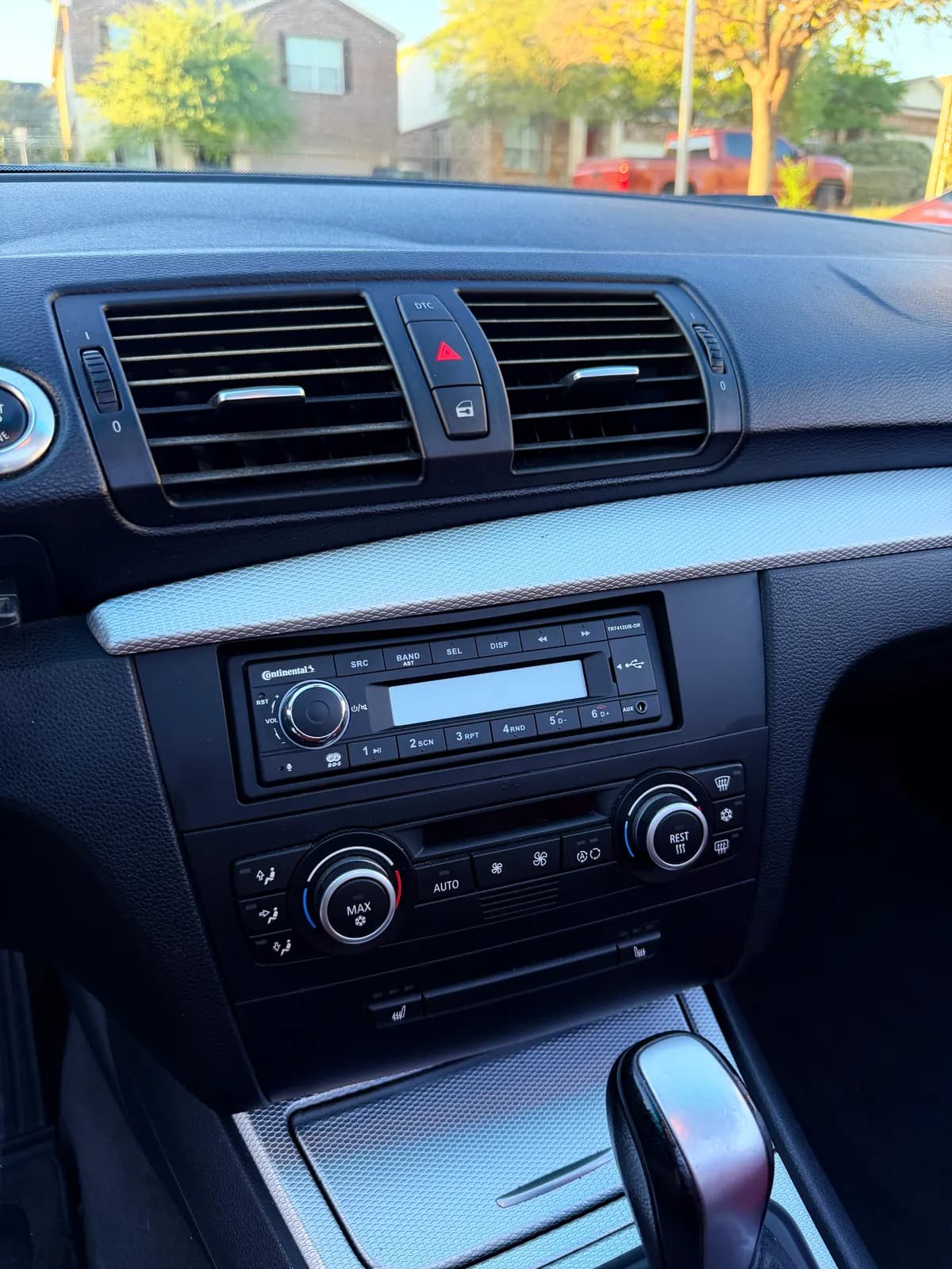 The BMW's center stack: vents, stereo, and climate dials, the brushed trim free of dust.