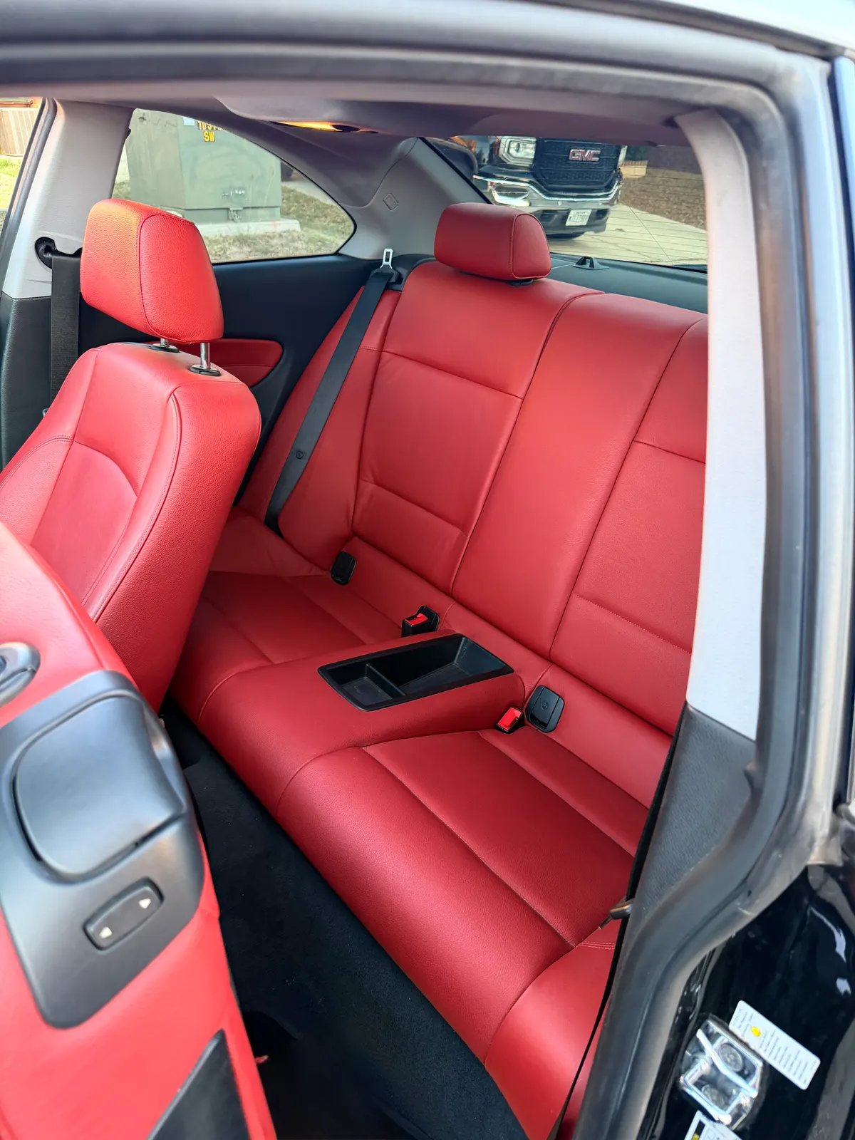 The BMW's red leather rear bench, creases cleaned and conditioned.